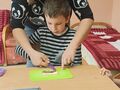 5. Nauczyciel pomagający uczniowi rozsmarowywać masło orzechowe 