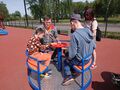 Plac zabaw na Błoniach w Krotoszynie Chłopcy siedzą na karuzeli tarczowej opiekun stoi obok i dostosowuje prędkość kręcenia karuzeliJPG
