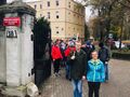Uczniowie wraz z nauczycielami wychodzą z bramy szkoły na pochód przez miejscowość Konarzew z przodu uczeń trzyma flagę Polski