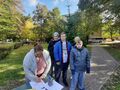 Uczniowie wraz z nauczycielką znajdują się w parku. Na fotografii widzimy trzech chłopców z wychowawczynią oraz dziewczynkę która stoi przy ław