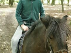 chłopiec siedzi na koniu