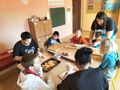 2. Uczniowie wraz z opiekunami podczas przygotowywania posiłku 