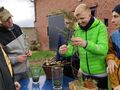 uczniowie wkładają znalezione w lesie fragmenty ściółki do słoików stoją na zewnątrz przed budynkiem