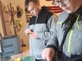 Dwóch chłopaków stoi przy blacie kuchennym nakłuwają gwoździami skórki od pomarańczy w celu zrobienia z nich karmników dla ptaków 
