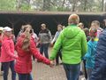 3. Harcerze tańczą trzymają się za ręce tworząc koło 