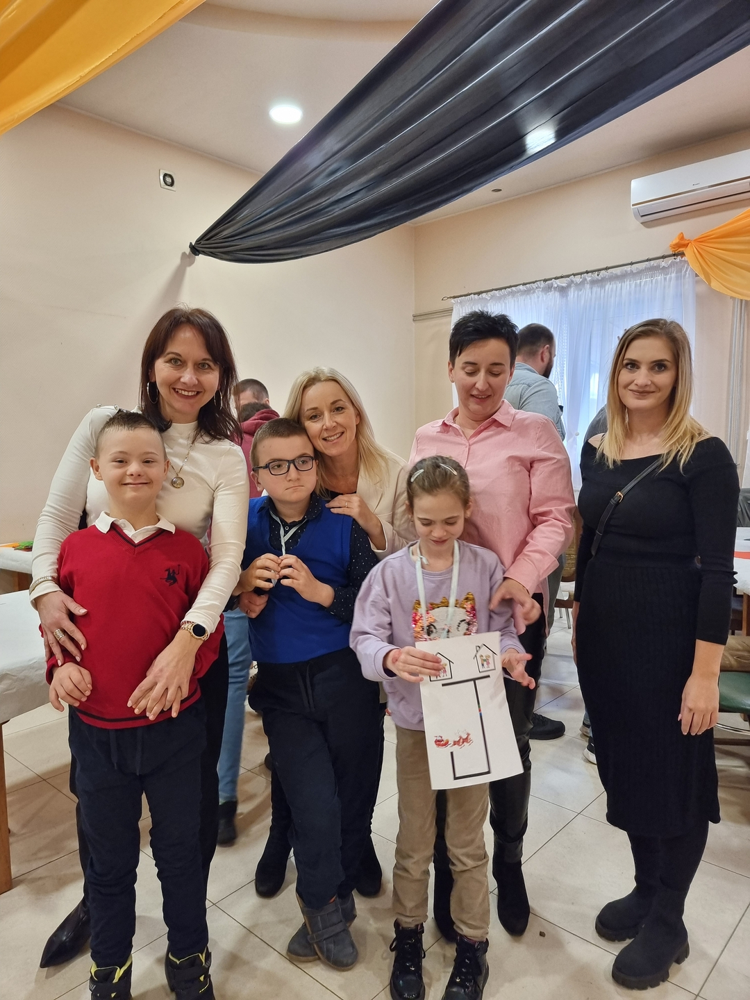 Dzieci z rodzicami i nauczycielkami pozują do zdjęcia