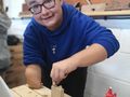 5 uczeń przykleja uszy do zrobionego z drewna kota