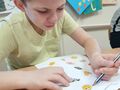 uczeń siedzi przy ławce w klasie i wykonuje ćwiczenie