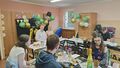 dzieci siedza przy stole w klasie w tle balony z liczbą 18 oraz napis happy birthday na stołach smakołyki ciasto paluszki wafelki