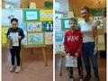 lauraci stoją przed pracami konkursowymi z dyplomem