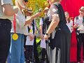 17.Na scenie uczestnicy kobieta w sukni odbiera dyplom i medal 