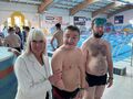 Krystian i Maciej pozują do zdjęcia razem z Panią Dyrektor będąc na zawodach pływackich. 