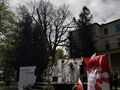 Uczniowie i nauczyciele w bieli tańczą na scenie z gałązkami bzu