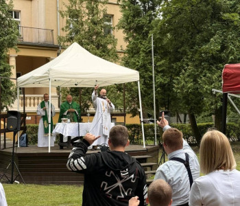 ksiądz odprawia mszę świętą w parku uczniowie i nauczyciele uczestniczą we mszy świętej