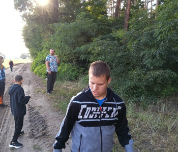 Uczniowie w trakcie spaceru szukają patyków, liści itp