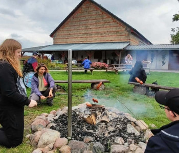 uczniowie smażą kiełbaski przy ognisku