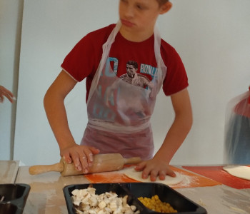 uczeń wałkuje cisto na pizzę