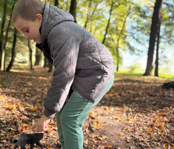 Chłopiec wbija w ziemię zwierzątko, które jest na wykałaczce