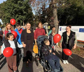 uczniowie podczas spaceru prezentują czerwone balony jako symbol walki z agresją