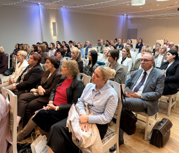 uczestnicy konferencji siedzą na krzesłach na sali konferencyjnej