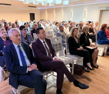 widownia siedzi na sali konferencyjnej
